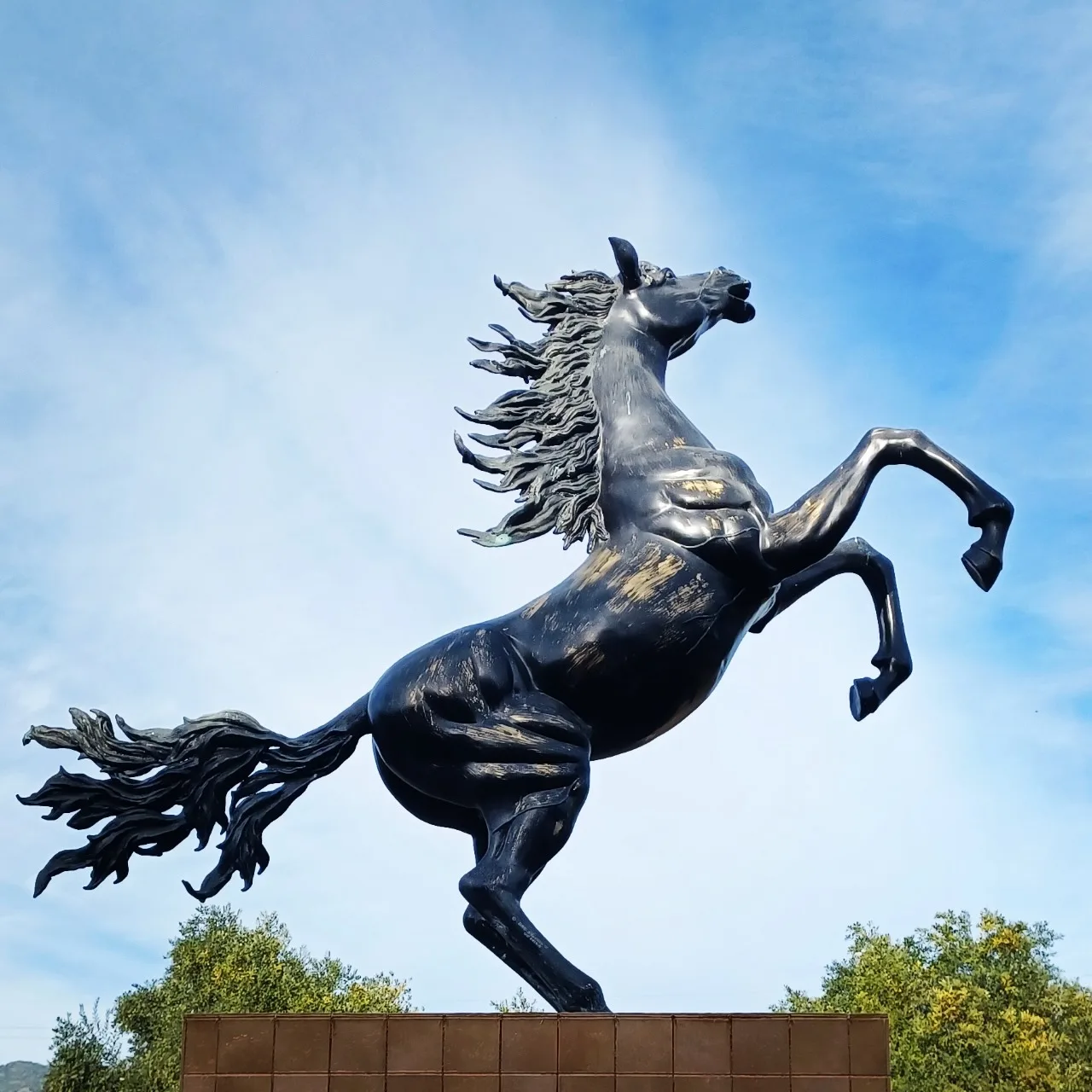 A rearing black horse sculpture against the Napa Valley sky